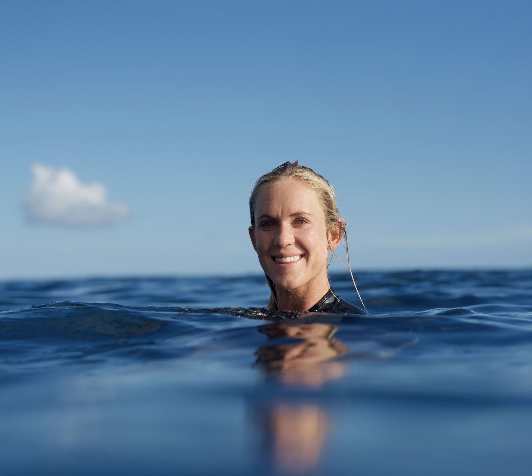 Bethany swims in the ocean to train for surfing
