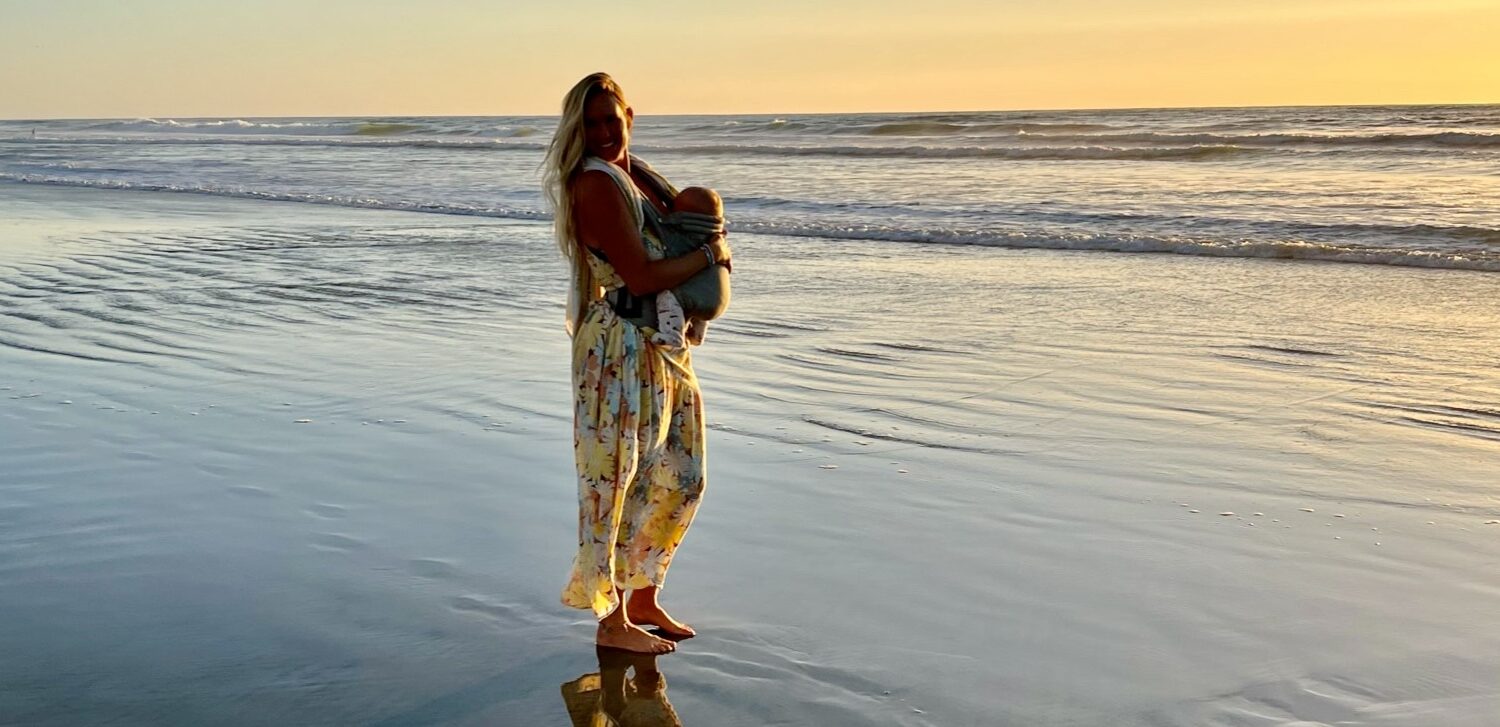 Bethany holds her baby while watching the sunset